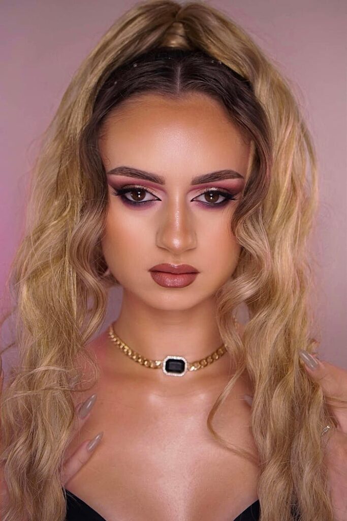 Close-up portrait showcasing intricate beauty makeup and an updo hairstyle.