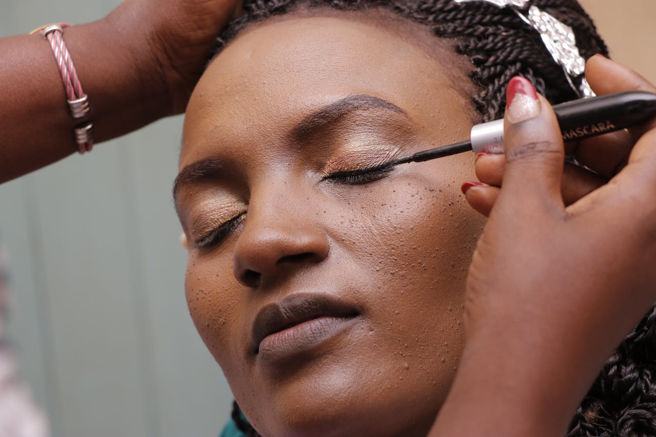 Close-up of a woman having mascara applied with precision.